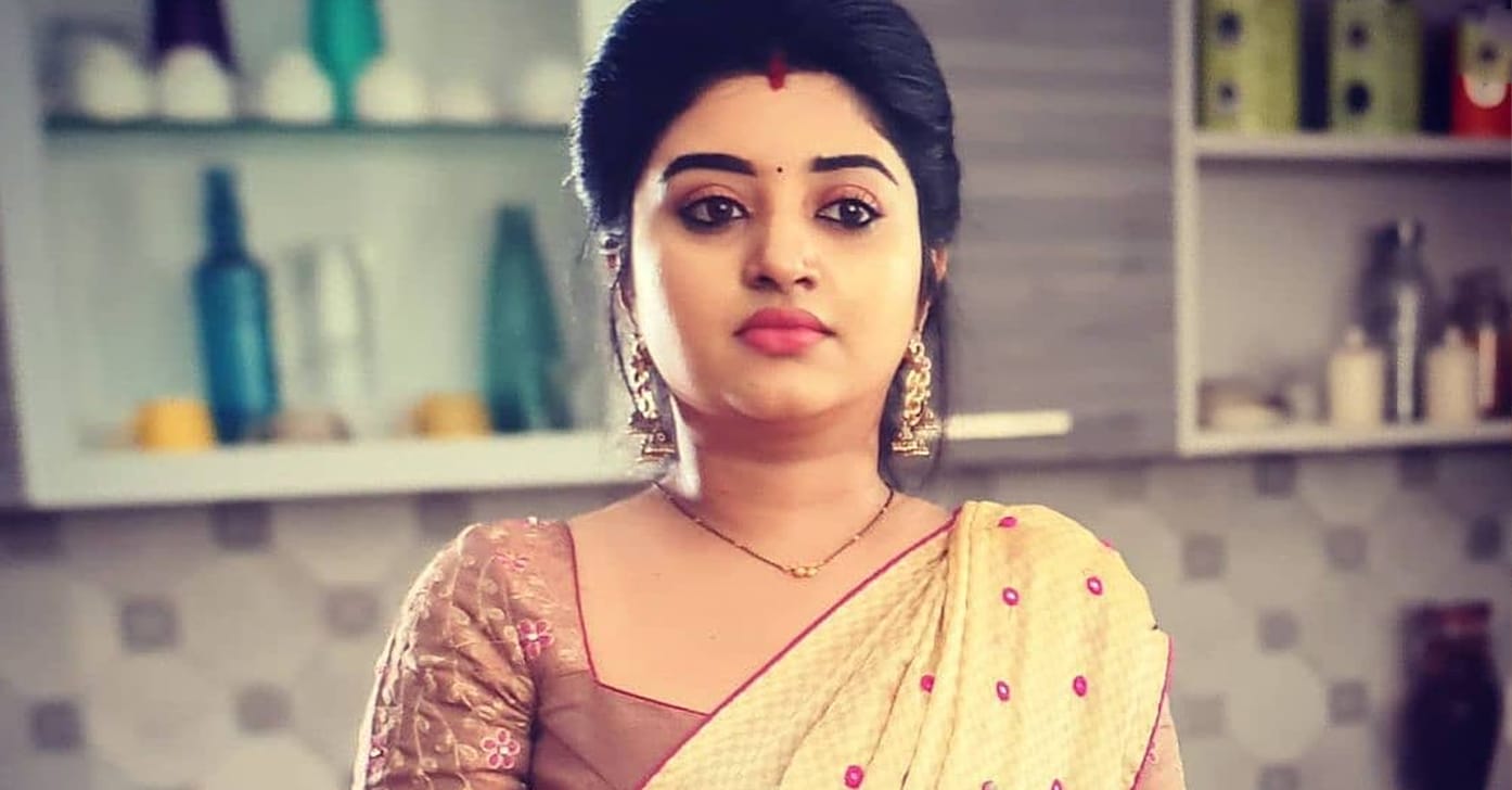 vj mahalakshmi golden saree standing in kitchen